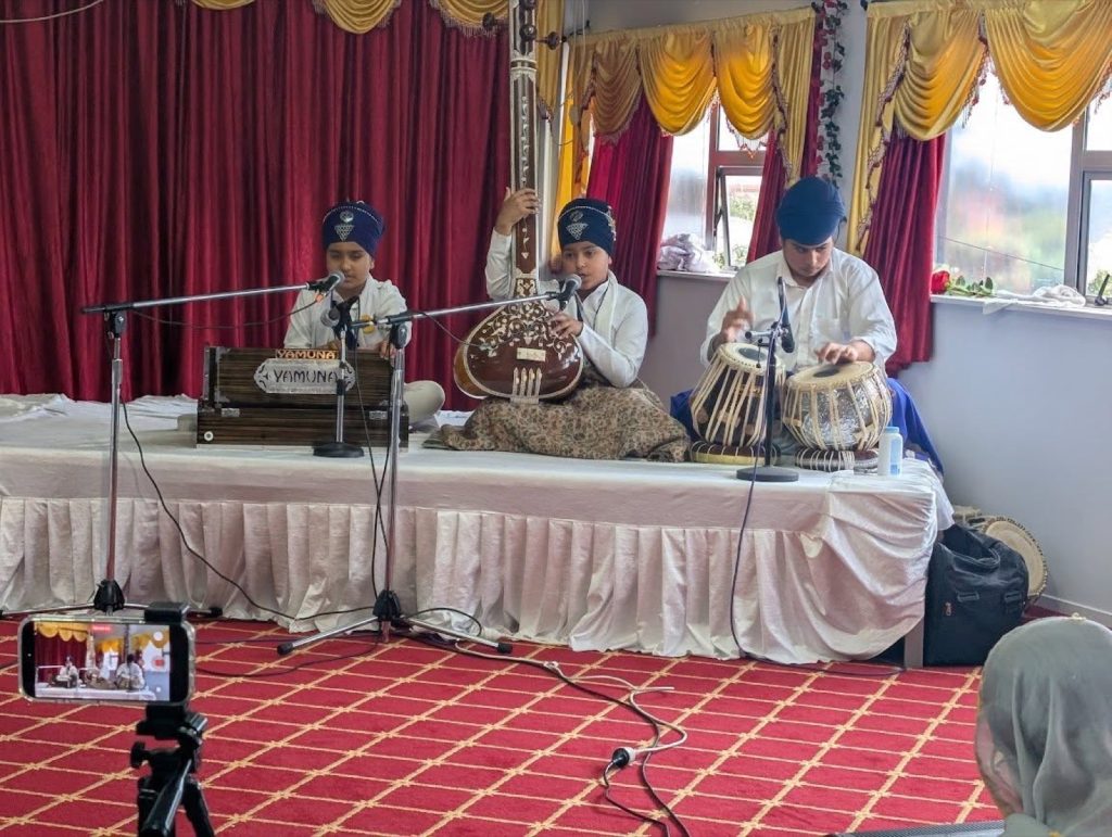 Students performing tabla and kirtan